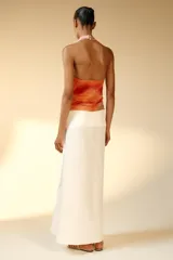 Falda midi de tiro medio confeccionada en hilatura con lino, con diseño de bajo asimétrico y cierre lateral con cremallera oculta.