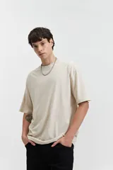 Remera de manga corta color beige, con escote redondo y corte oversize.