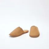Pantuflas cerradas de terciopelo color marrón camel, con ribetes al tono y suela plana.