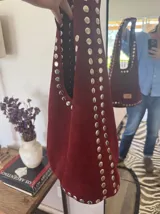 Bolso negro de gamuza con tachas plateadas.