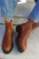 Bota tipo chelsea de cuero color chocolate, con paneles laterales elásticos y suela track de goma negra.