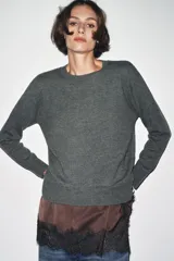 Jersey de punto liso color verde, con cuello redondo y manga larga. Confeccionado en lana suave.