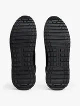 Zapatillas deportivas Tommy Hilfiger de estilo running, confeccionadas en una mezcla de piel y poliuretano. Presentan un diseño de corte bajo con cordones, paneles de texturas mixtas, detalles de ventilación en la parte superior y suela de goma con tacos.