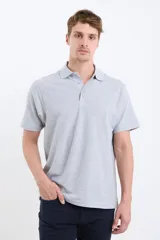 Chomba de piqué color gris claro, de corte clásico, con cuello polo abotonado y mangas cortas.