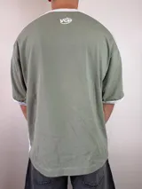 Remera de diseño estilo jersey deportivo con calce oversize, color blanco con mangas cortas negras y detalles de franjas blancas en los hombros. Cuenta con estampado frontal con texto y logotipos.