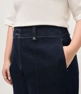 Pantalón de jean wide leg color azul oscuro, confeccionado en algodón resistente, de tiro alto con costuras frontales destacadas en las piernas y diseño de pernera ancha.