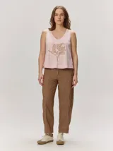 Pantalón estilo barrel de lino color marrón con sutiles rayas verticales en tonos claros, de corte recto y holgado.