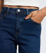 Pantalón skinny de tiro alto confeccionado en denim azul oscuro. Presenta un diseño clásico con cierre de cremallera y botón, trabillas para cinturón y bolsillos funcionales tanto en la parte delantera como en la trasera.