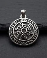 Collar con dije circular de acero de diseño celta en relieve, suspendido de una cadena fina de eslabones plateados.