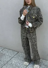 Campera de denim con estampado animal print de leopardo, con cuello clásico, cierre frontal con botones dorados y bolsillos laterales. Pantalón haciendo juego.