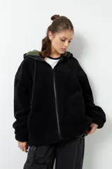 Campera tipo canguro teddy negra con capucha y cierre. El forro es de felpa color verde militar.