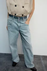Jeans de tiro medio con cinco bolsillos, diseño holgado y efecto desgastado con detalles de rotos. Cuenta con una cintura doble combinada en contraste de tonos denim y cierre frontal con cremallera y botones metálicos.
