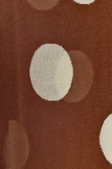 Vestido largo de punto marrón con cuello redondo y sin mangas, con estampado de lunares grandes en color crema.