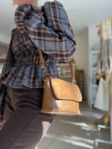 Jean de corte carrot color chocolate, confeccionado en denim con elastano. Presenta un diseño de tiro medio con ajuste holgado en la cadera y pierna que se estrecha hacia el tobillo.