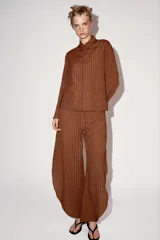 Camisa de viscosa de la colección ZW de Zara, con diseño de rayas verticales, cuello mao y cierre frontal con alamares. Tiene mangas largas y bolsillos frontales de parche.