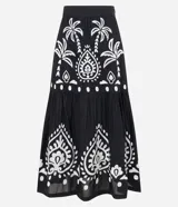 Pollera midi de algodón con diseño acampanado y cierre lateral. Presenta un estampado contrastante de palmeras y motivos arabescos sobre fondo oscuro.