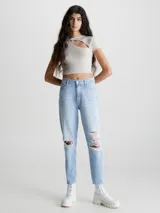 Jeans de mujer estilo mom, tiro alto, color celeste claro con efecto lavado y roturas grandes en ambas rodillas. El largo es tobillero.