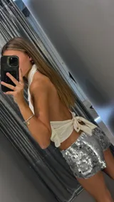 Short de tiro bajo confeccionado en tela cubierta de lentejuelas plateadas brillantes, con ajuste elástico en la cintura.