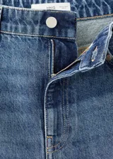 Pantalón de jean estilo wide leg con tiro medio, cierre frontal de cremallera y botón, cinco bolsillos y detalle de tachuelas en la cintura.