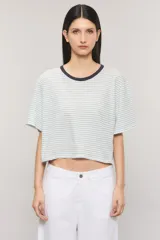 Remera boxy de algodón con estampado de rayas celestes sobre fondo blanco, cuello redondo oscuro y mangas cortas.