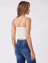 Top corto de encaje elastizado con breteles finos ajustables, sujetador interno y copas preformadas.