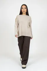 Pantalón de corte recto y tiro alto en color marrón, con bolsillos laterales y cierre frontal con botones.