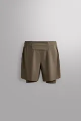 Short de running 2 en 1 color beige, confeccionado en tejido técnico ligero y elástico con malla interior integrada. Presenta cintura elástica ajustable con cordón, bolsillo trasero con cierre y aberturas laterales en el bajo.