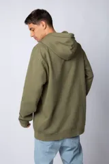 Buzo canguro oversize de tela friza, color negro, con capucha, cordones ajustables con logo y bolsillo frontal tipo canguro.