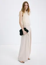 Top de punto fino color beige, con diseño recto, cuello redondo, tirantes anchos y detalles fruncidos con capas semitransparentes.