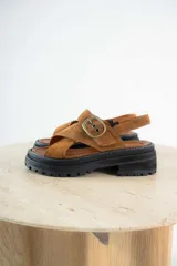 Sandalias de cuero color tostado y blanco, con plataforma track y hebilla metálica.