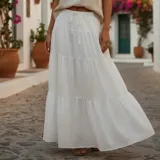 Pollera larga blanca de tiro alto con diseño acampanado y volados en capas. Cuenta con cintura elástica fruncida y lazo ajustable del mismo tejido.