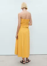 Vestido midi de color amarillo con cuerpo tipo corset fruncido y falda evasé de corte amplio. Presenta un diseño sin tirantes y está confeccionado en una mezcla de algodón con textura.