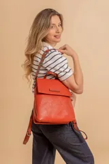 Mochila tipo cartera con tapa, confeccionada en material símil cuero. Cuenta con doble compartimento principal, división interna y bolsillo trasero con cierre. Incluye correas ajustables y detalles metálicos en los enganches.