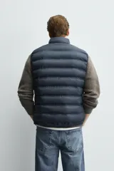 Chaleco acolchado de hombre color negro, con diseño puffer, cuello alto y cierre frontal con cremallera.