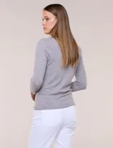 Buzo tejido fino y suave de marca Elie Tahari, color gris, con escote redondo pronunciado, mangas largas y silueta semi entallada.