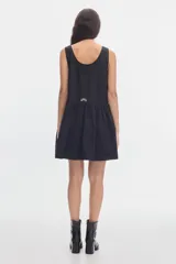 Vestido corto negro de algodón, con escote en V cruzado, sin mangas y falda con fruncido en la cintura.