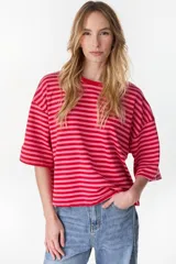 Remera oversize de manga corta a rayas horizontales en tonos rojo y rosado, con cuello redondo.