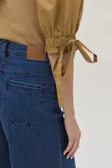 Top color camel con mangas abullonadas con lazos y escote en V.