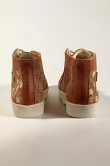 Botas de media caña de cuero color terra con brillo jaspeado en tono cobre, con detalles de arte pintado a mano en el talón, suela de goma blanca y cordones beige.