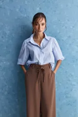 Pantalón wide leg de color negro, con cintura de tiro alto, lazo ajustable y caída fluida.