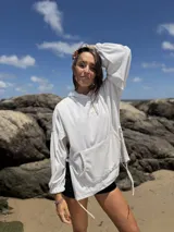 Canguro oversize color crudo de plush suave, con capucha ajustable, mangas globo, bolsillo tipo canguro, puños fruncidos y tajos laterales con tiras ajustables.