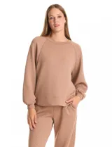 Buzo de cuello redondo con mangas largas tipo raglán y puños elásticos. Presenta un sutil estampado animal print tono sobre tono en toda la prenda, con un diseño holgado y cómodo.