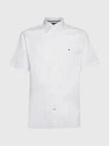 Camisa blanca de manga corta confeccionada en popelín de puro algodón, con cuello abotonado, corte regular y logo de Tommy Hilfiger bordado en el pecho.