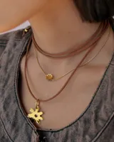 Collar de cadena tipo snake dorada con dije central en forma de flor de acrílico espejado.