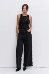 Body sin mangas de color negro, con cuello redondo y detalle de strass aplicado en toda la parte frontal.