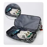 Bolso deportivo de viaje marca Zuomanni, con estampado animal print de leopardo en blanco y negro. Cuenta con doble asa de mano, correa de hombro ajustable y extraíble, y un compartimento inferior independiente con cierre.