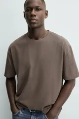 Camiseta de corte relajado confeccionada en algodón con textura irregular, cuello redondo y manga corta.