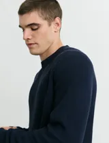 Sweater de punto inglés con escote redondo y mangas largas. Presenta cuello y puños terminados en punto canalé.