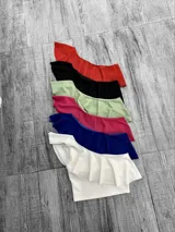 Top corto con un solo hombro y volado grande.