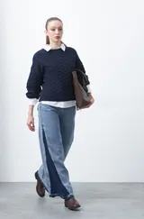 Sweater de punto tramado color azul marino, con cuello redondo, mangas abullonadas y puños elastizados.